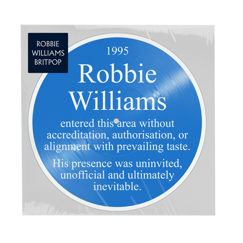 Front view of a blue picture disc in English “Blue Plaque” style reading '1995 Robbie Williams entered this area without accreditation, authorisation, or alignment with prevailing taste. His presence was uninvited, unofficial and ultimately inevitable. 